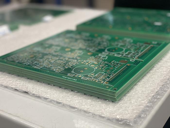 A pile of green rigid printed circuit boards ready for packing on bubble wrap