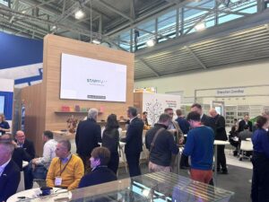 People milling around, chatting, at the Starteam stall at the Electronica exhibition in 2024