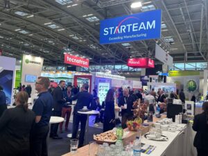 People milling around, chatting, at the Starteam stall at the Electronica exhibition in 2024