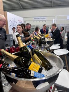 Bottles of wine in the foreground with people chatting in the background at Electronica in 2024